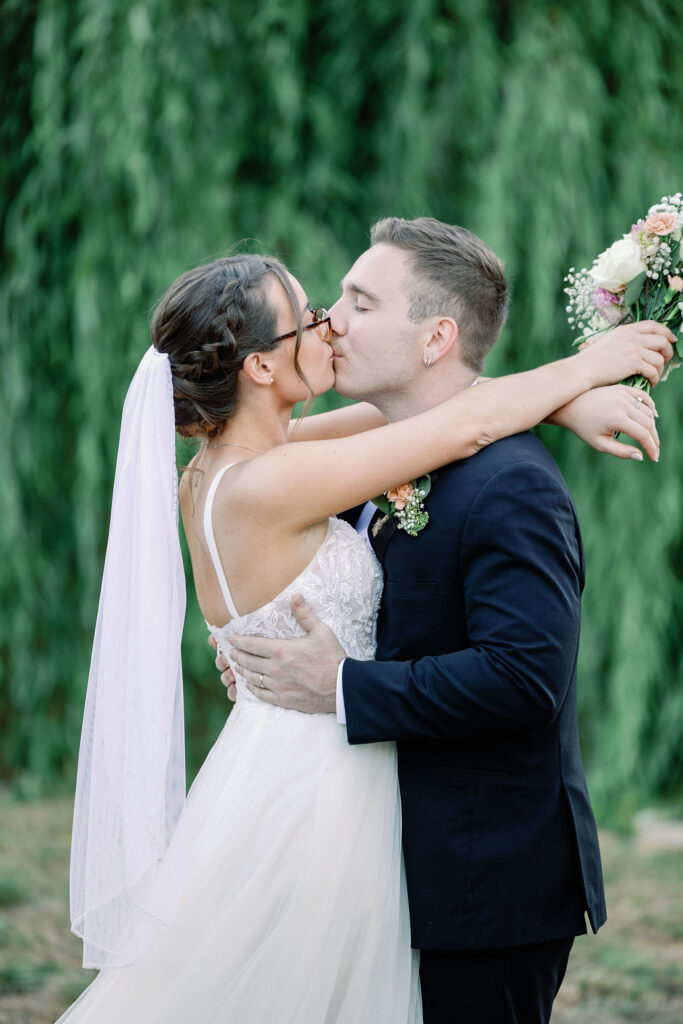Bay Area photographer captures groom kissing bride during outdoor bridal portraits