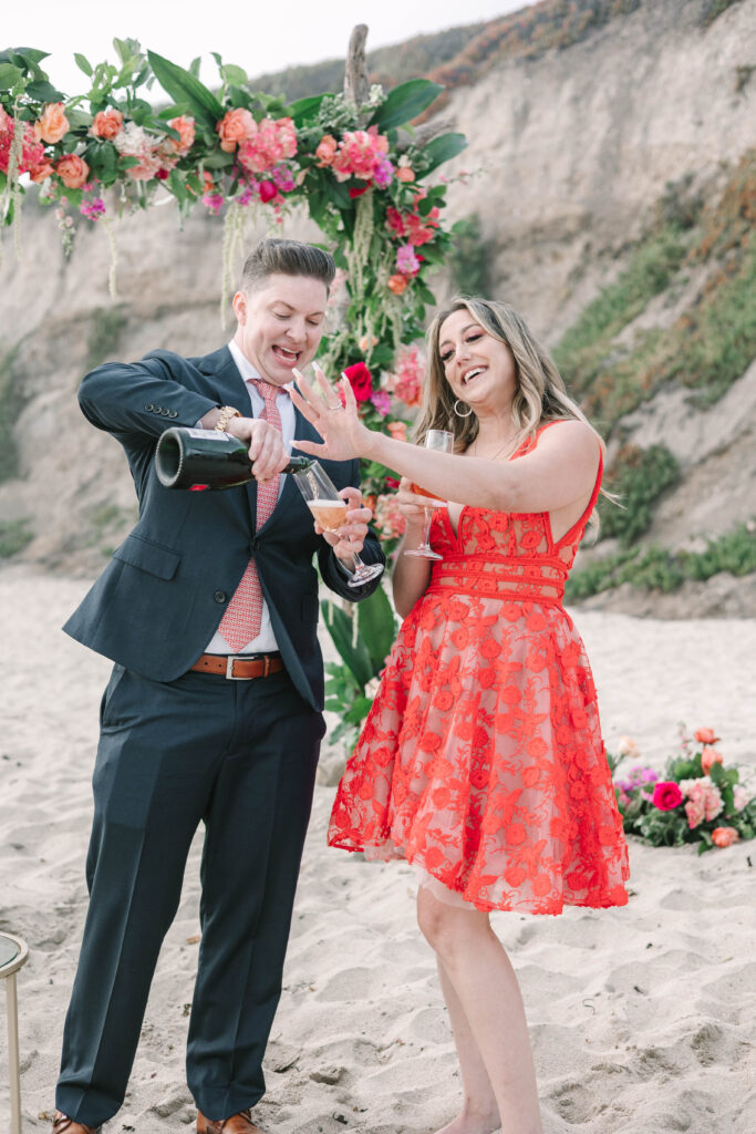 Bay Area wedding photographers capture man pouring champagne and woman admiring engagement ring