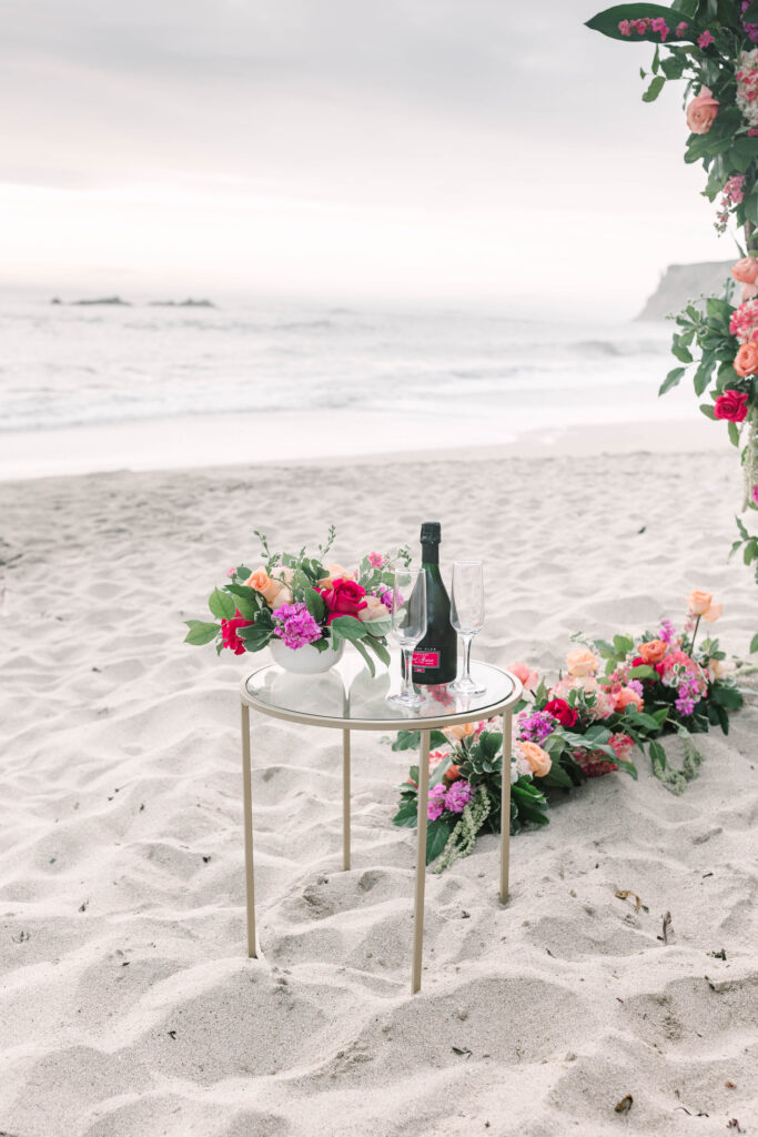 Bay Area wedding photographers capture table with flowers and champagne on beach