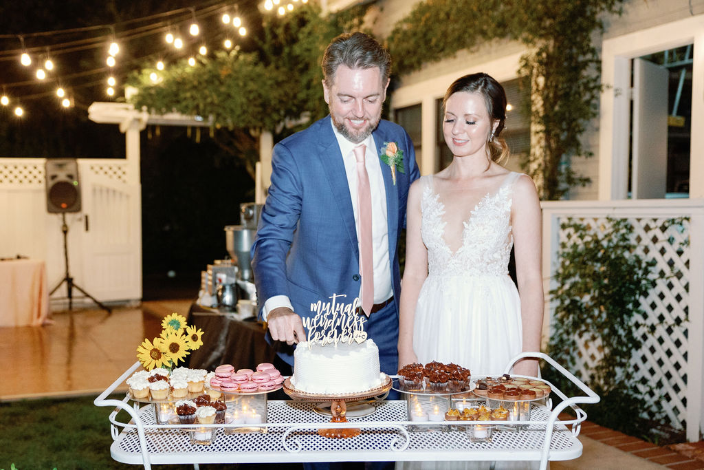 Bay Area wedding photographer captures bride and groom cutting. cake together