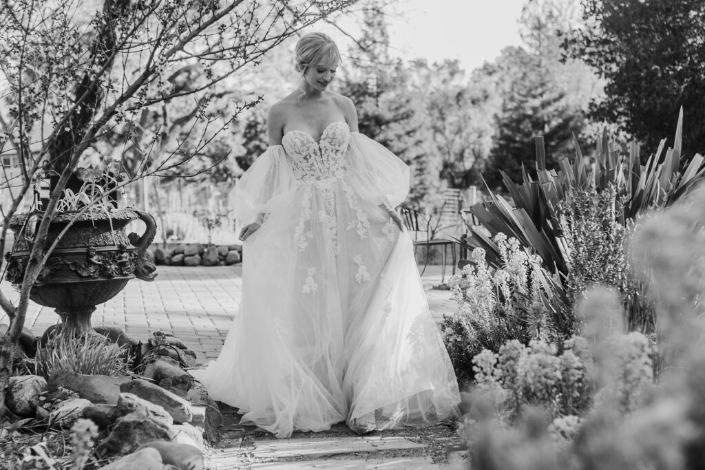 Bay Area photographer captures black and white portrait of bride walking through garden
