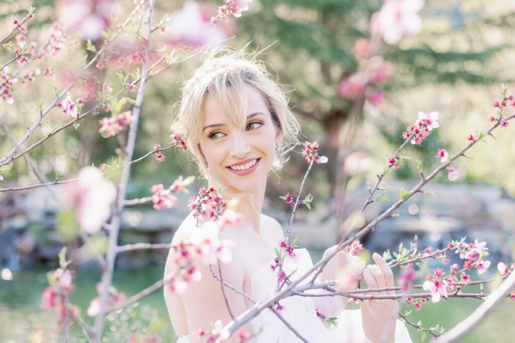 Bay Area wedding photographer captures bride smiling in cherry blossoms