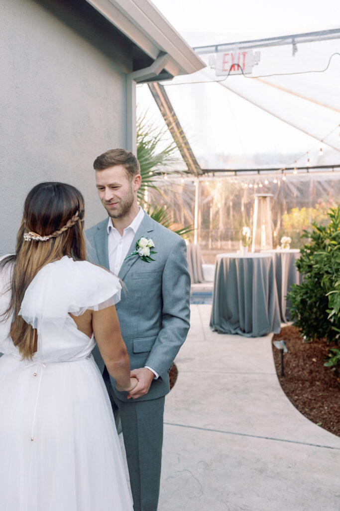 Bay area photographers capture groom holding bride's hans during first look