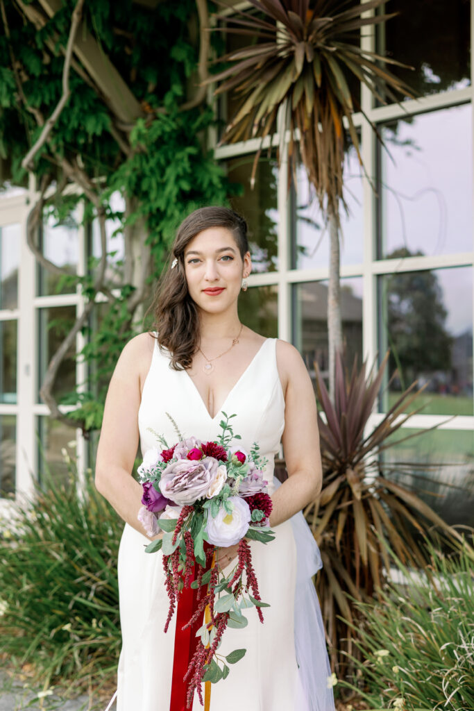 Bay Area wedding photographer captures bride holding bridal bouquet with red ribbon