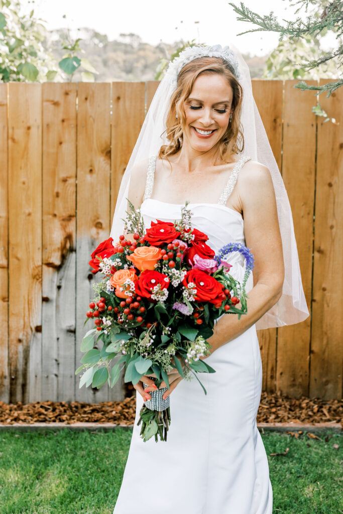 Bay Area wedding photographer captures bride holding red bouquet 