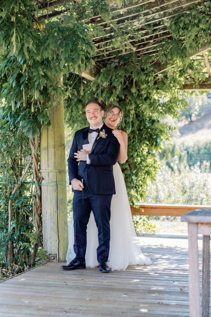Bay Area photographers capture groom smiling while bride hugs him