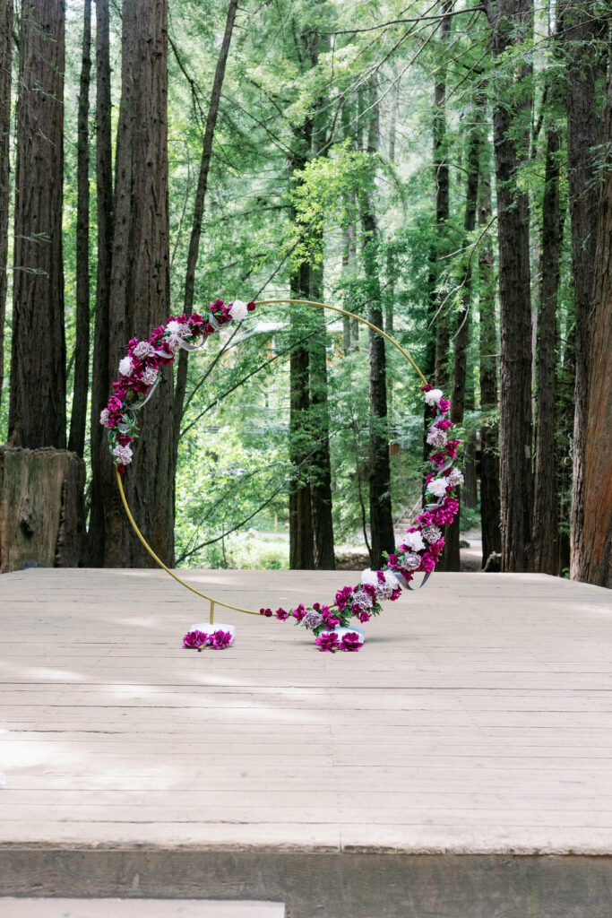 Bay Area wedding photographer captures gold wedding arch with purple flowers around it