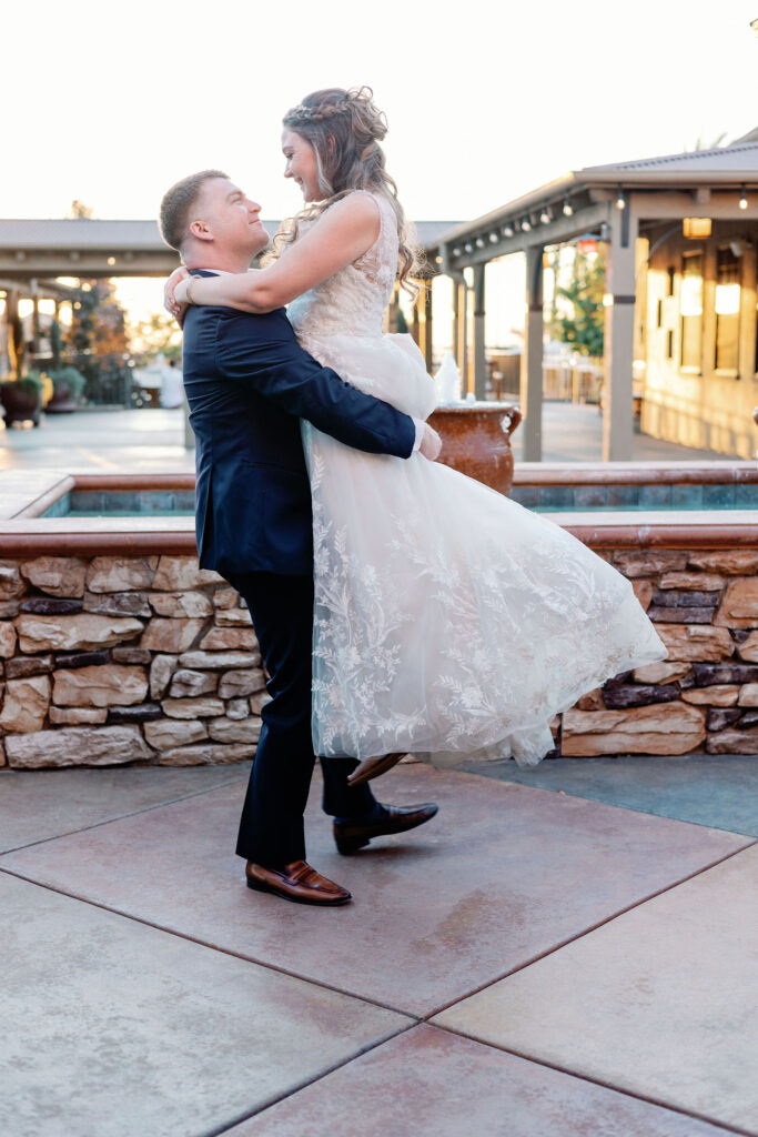 Bay Area photographers capture groom lifting bride up in wedding attire