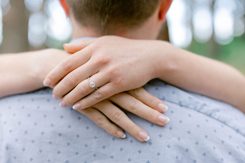 Bay Area wedding photographer captures woman's arms around man's neck showing engagement ring