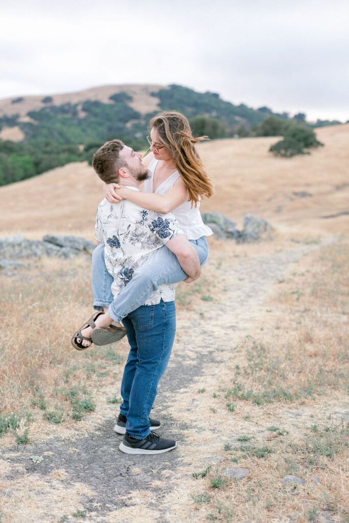 Bay Area wedding photographer captures man lifting woman and holding her
