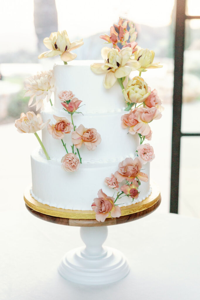 Bay Area wedding photographer captures three tiered wedding cake with flowers on it