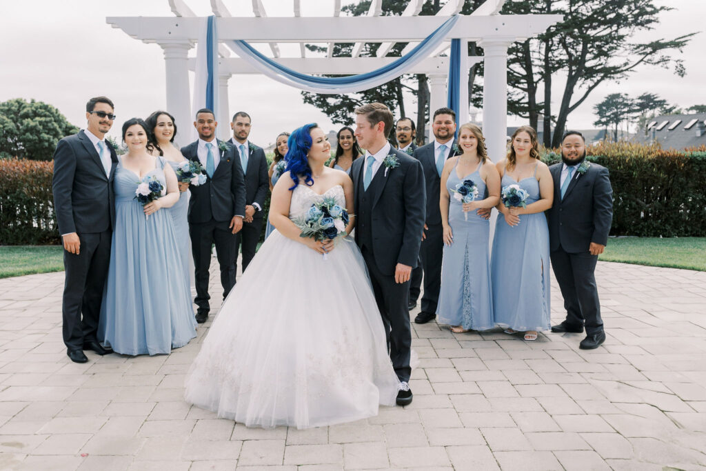 Sacramento wedding photographer captures bride and groom standing together with bridal party behind them