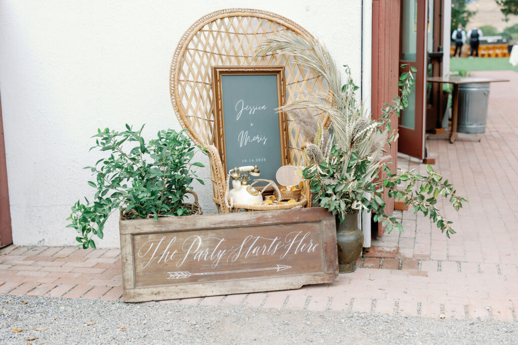 Bay Area wedding photographer captures boho chair and chalkboard sign at backyard wedding 