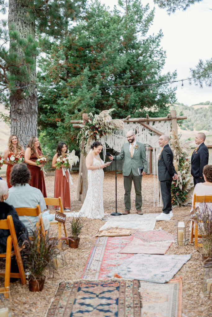Bay Area wedding photographer captures bride and groom reading vows to one another at backyard wedding