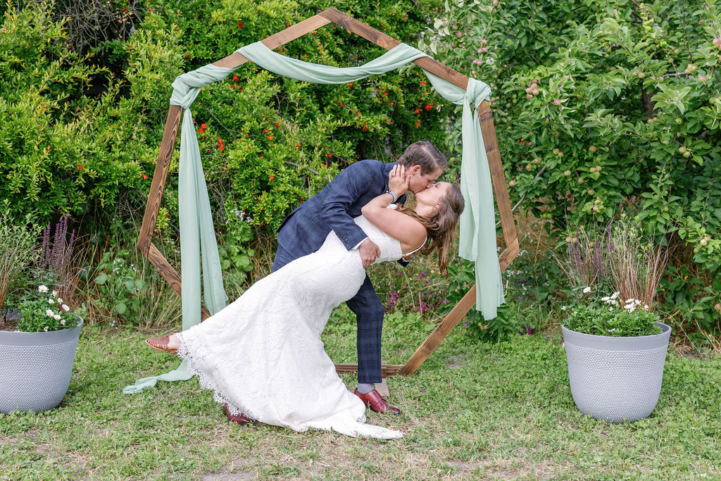 Bay Area wedding photographer captures bride and groom dip kiss after backyard wedding ceremony 