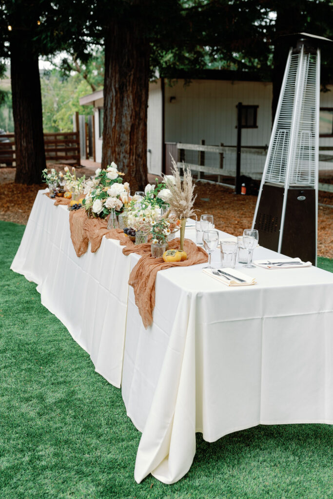 Bay Area wedding photographer captures long table with rust and white elements to add to the backyard wedding decor