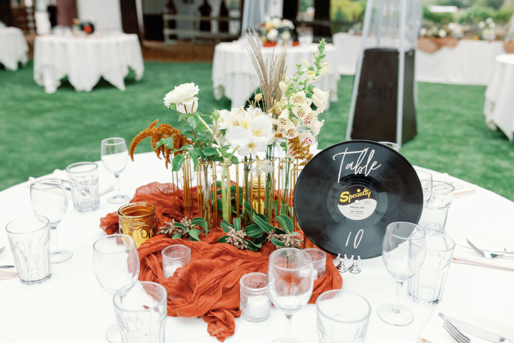 Bay Area wedding photographer captures table with records as centerpieces at backyard wedding