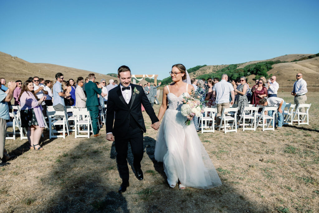 Bay Area wedding photographer captures bride and groom walking out of ceremony as newly married couple
