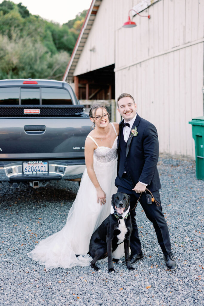 Bay Area wedding photographer captures bride and groom standing together smiling with dog