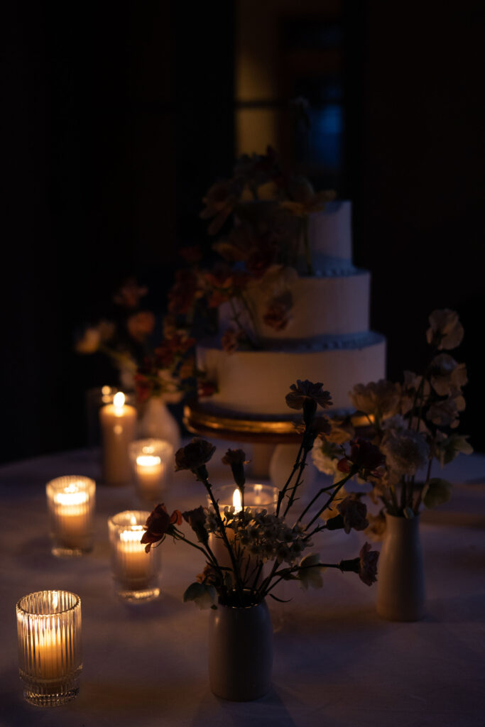 Bay Area wedding photographer captures candlelit backyard wedding with wedding cake lit up by candles