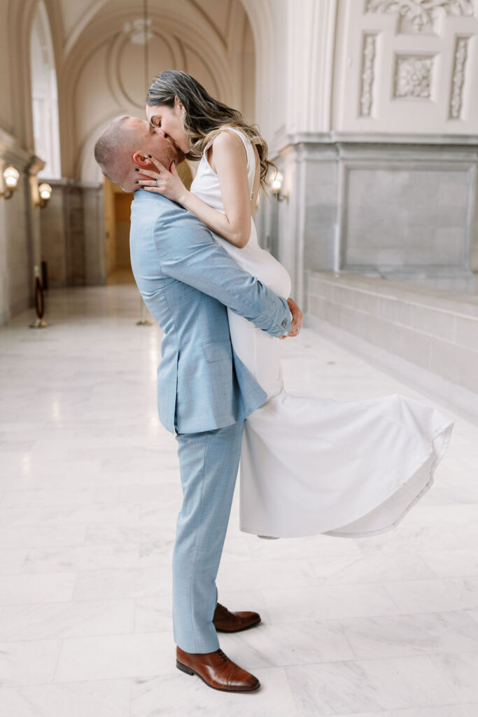 Bay Area wedding photographer captures groom lifting bride to kiss her