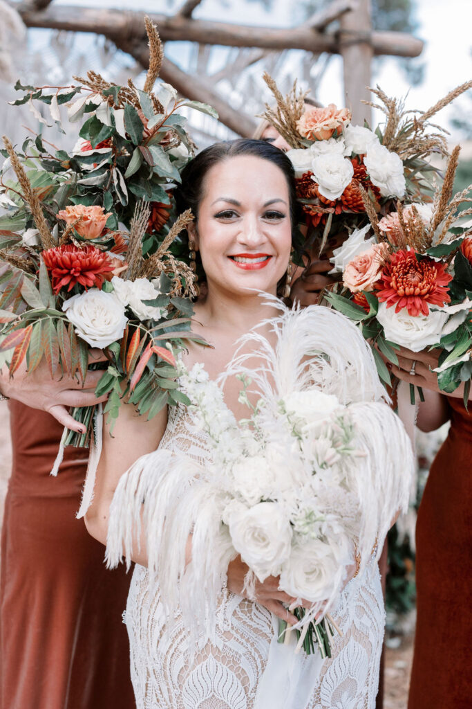 Bay Area wedding photographer captures bride holding bouquet with other bouquets around her