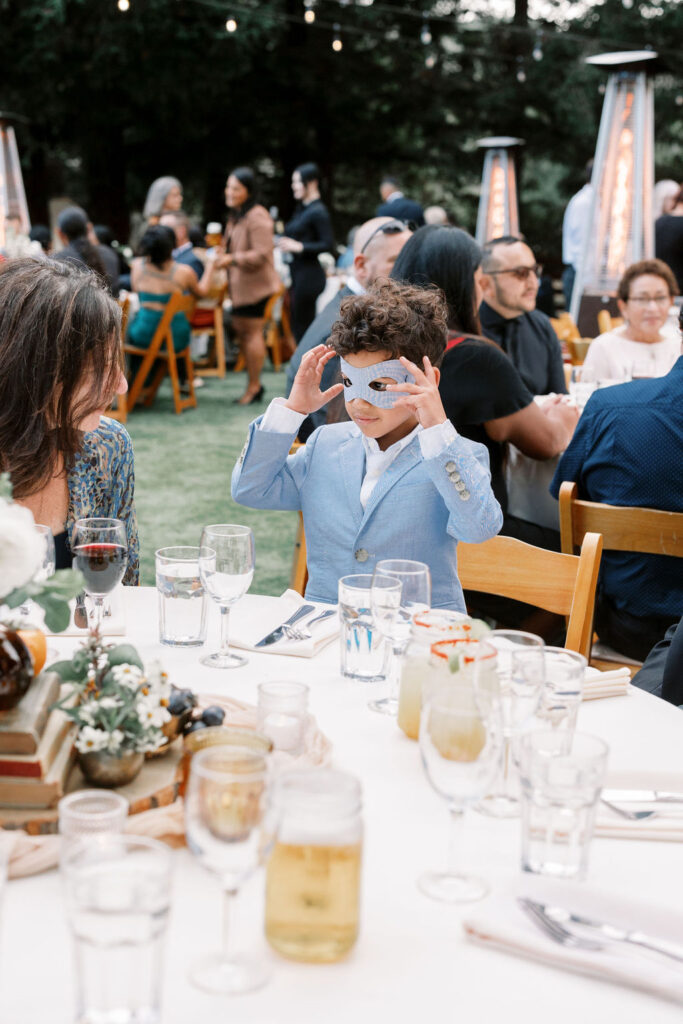 Bay Area wedding photographer captures kid wearing paper mask at outdoor wedding