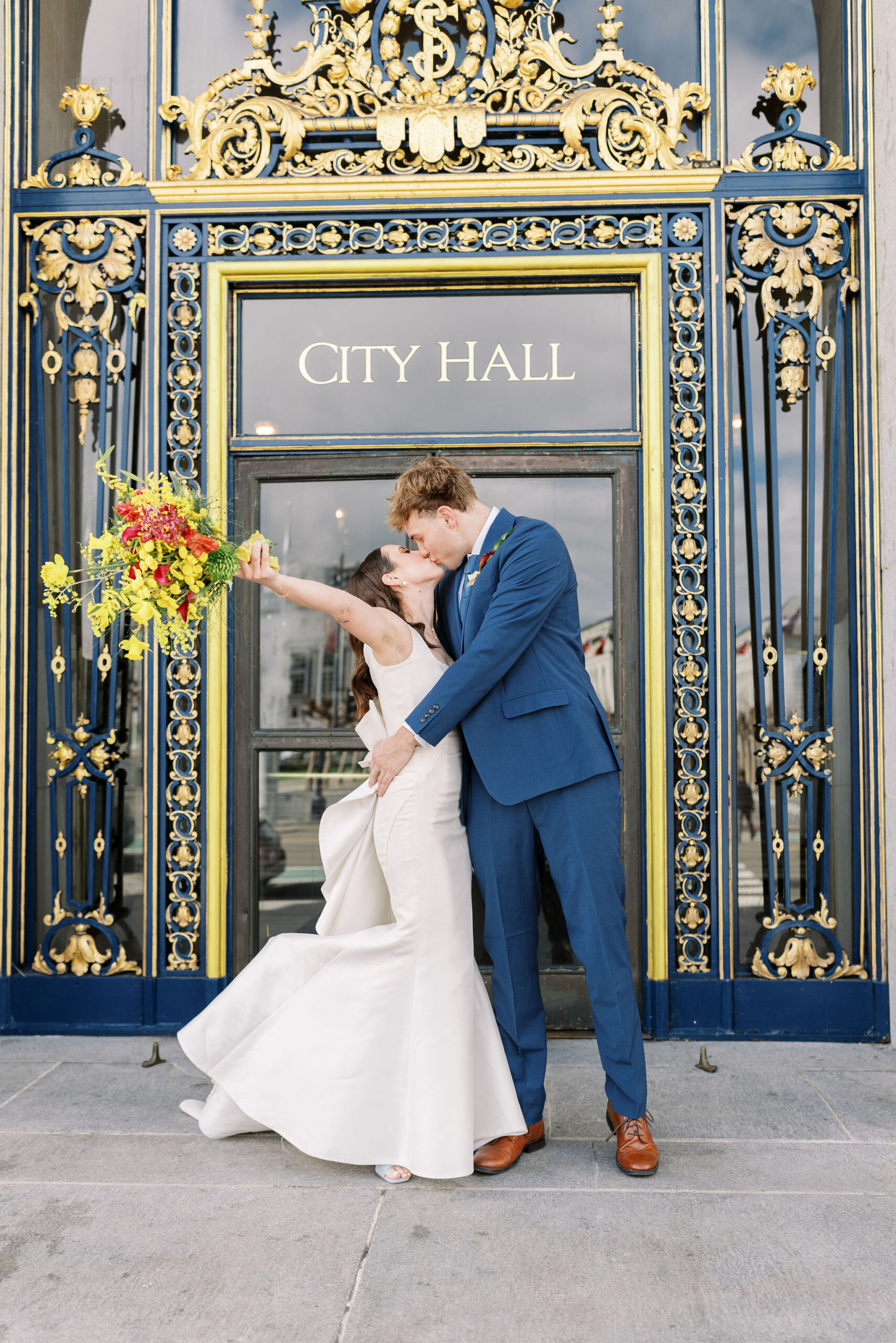 bride and groom kissing outside of the city hall in celebration of their elopement photographed by Bay Area wedding photographer