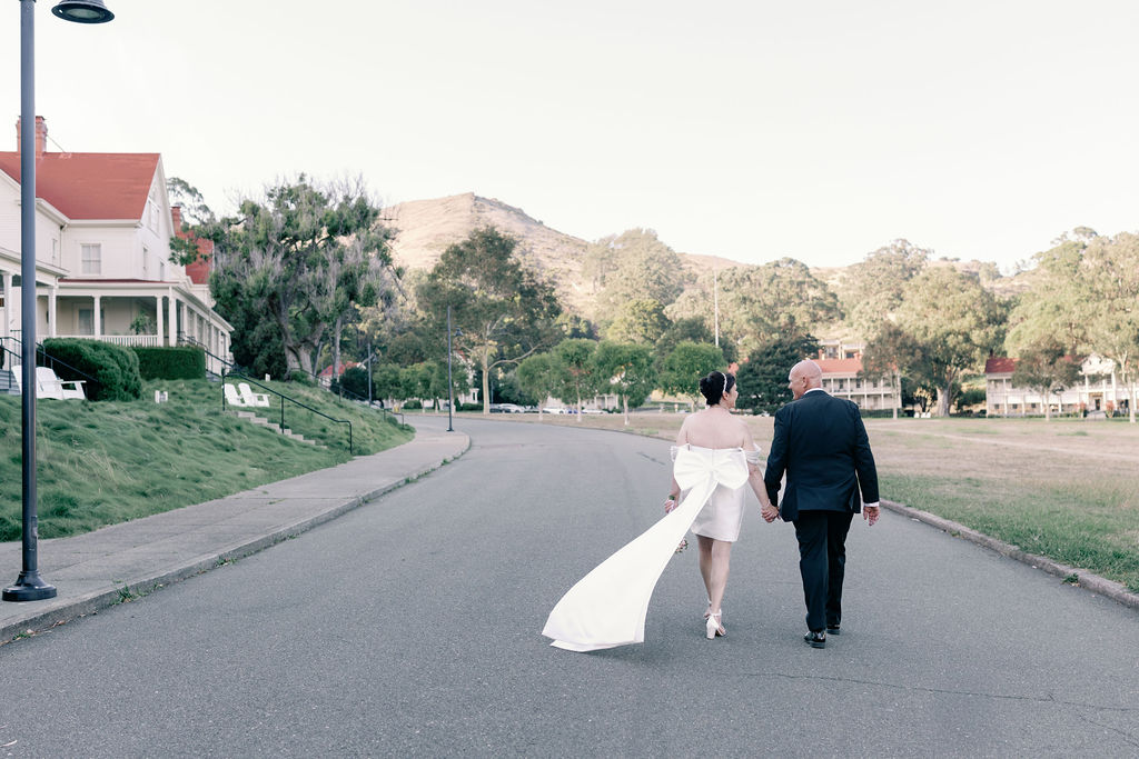 a bride and groom walk along the street at cavallo point